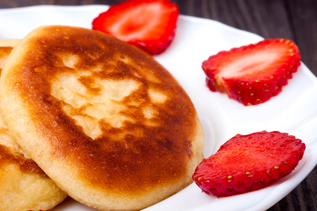 fritters on a plate with strawberries on wooden background.の写真素材