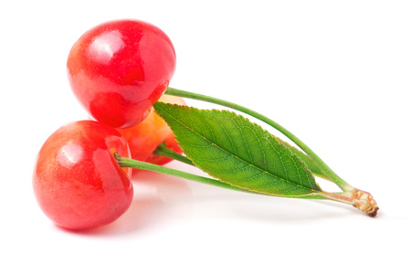 Three cherries with leaf closeup isolated on white background.の写真素材