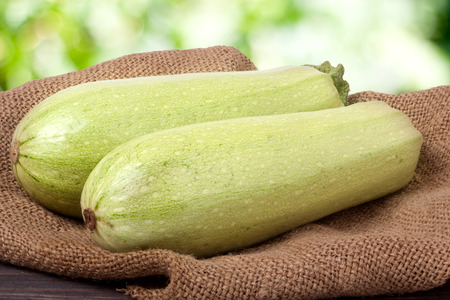 two courgettes on sackcloth with a blurred background.の写真素材