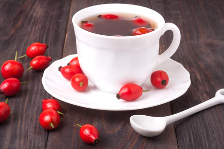 cup with rose hip tea on a dark wooden background.の写真素材