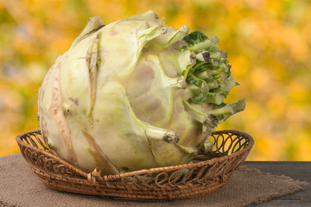 fresh cabbage kohlrabi in a wicker bowl on a dark wooden table with a blurred background.の写真素材