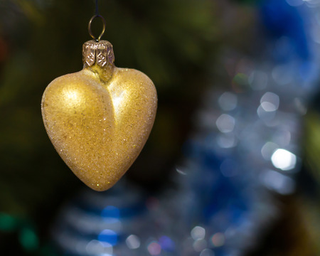 yellow heart hanging on the Christmas tree closeup.の写真素材