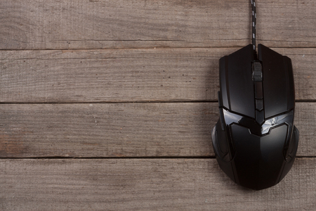 black computer mouse on an old wooden background with copy space for your text. Top viewの写真素材