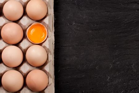 eggs in a tray on a dark background with copy space for your text. Top view