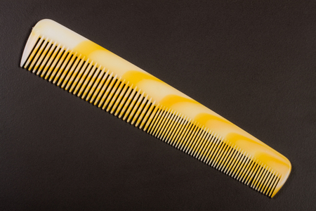 one yellow hairbrush on a dark backgroundの写真素材