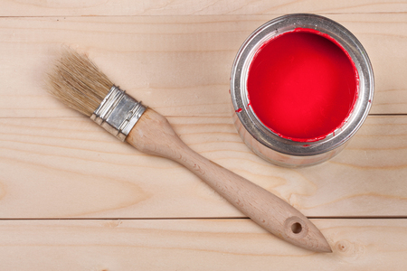 red paint in the bank to repair and brush on the light wooden backgroundの写真素材