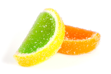 colorful jellies like slices of lemon and orange isolated on white backgroundの写真素材