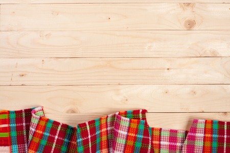 Red checkered tablecloth on a light wooden table with copy space for your text. Top viewの写真素材
