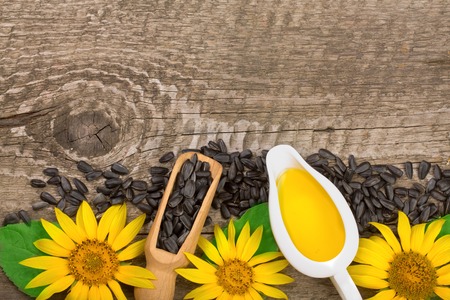 Sunflower oil, seeds and flower on wooden background with copy space for your text. Top view.の写真素材