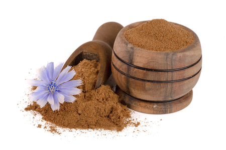 chicory powder in a bowl and scoop with a flower isolated on white backgroundの写真素材