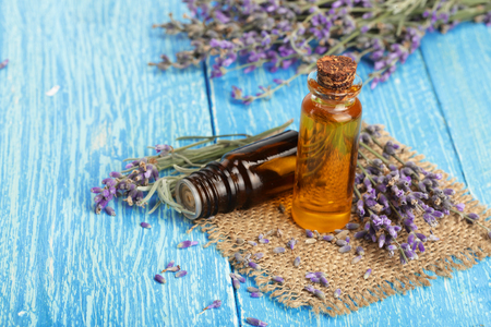 Herbal oil and lavender flowers on wooden backgroundの写真素材