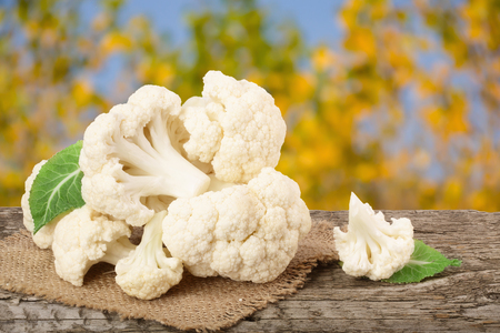 Piece of cauliflower on wooden table with blurred garden background.の写真素材