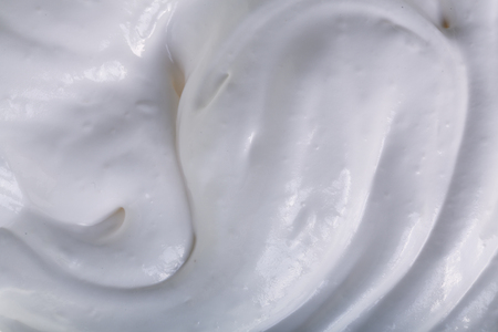 close up of a white whipped or sour cream on white background.の写真素材