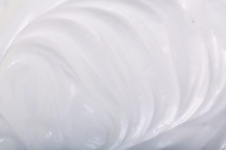 close up of a white whipped or sour cream on white background.の写真素材