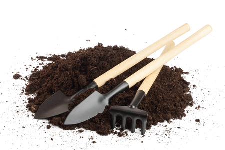 garden tools in soil isolated on white backgroundの写真素材
