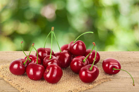 red sweet cherry on wooden table isolated on white background