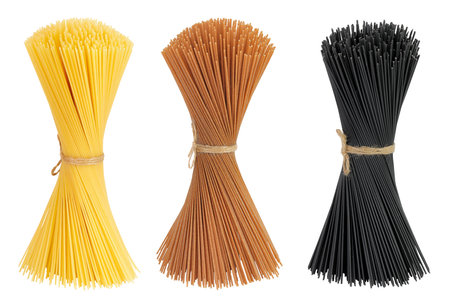 uncooked black, brown and yellow spaghetti isolated on white backgroundの写真素材