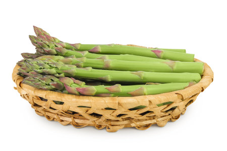 fresh asparagus in in a wicker basket isolated on white backgroundの写真素材