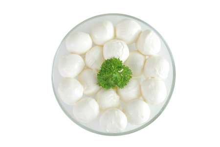 Mini mozzarella balls with parsley in a glass bowl isolated on white background. Top view. Flat lay.の写真素材