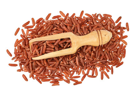 red rice in a wooden scoop isolated on white background. Top view. Flat layの写真素材