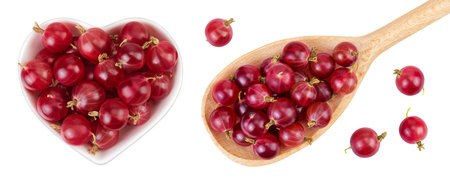 Red gooseberry in ceramic bowl and wooden spoon isolated on white background. Top view. Flat lay.