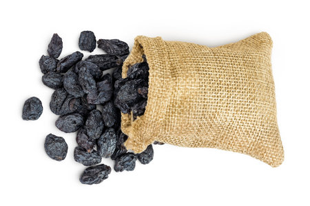 black raisins in bag isolated on white background. Top view. Flat layの写真素材