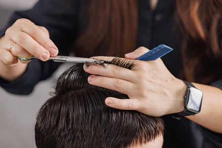 professional hairdresser cuts a guy's hair in a beauty salon, men's haircuts close-upの写真素材