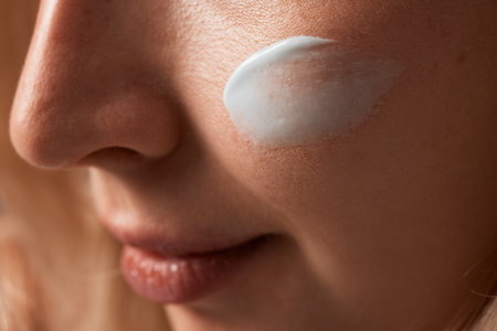 Close up beauty portrait laughing beautiful half naked woman applying face cream make up health spa fresh skinの写真素材