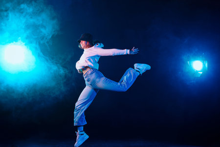a girl in light clothes dances on a neon background in smoke, modern dance