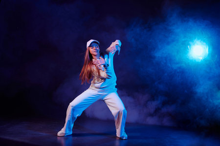 a girl in light clothes dances on a neon background in smoke, modern danceの写真素材
