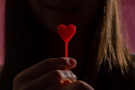 closeup hands holding heart on pink background, valentine's day conceptの写真素材