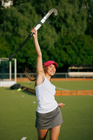 girl hockey player plays field hockey on a sunny day, female hockey player celebrates a goal scored,...