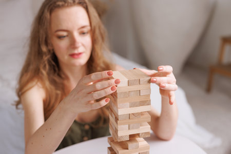 two women playing a board game made of wooden blocks at home, excitement and relaxation, mind development concept, hand motor skills,の写真素材