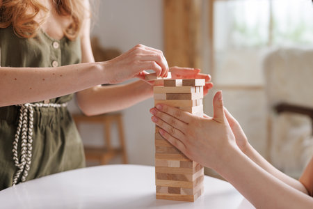two women playing a board game made of wooden blocks at home, excitement and relaxation, mind development concept, hand motor skills,の写真素材