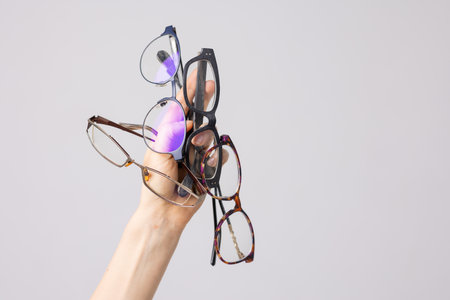 hand holding many glasses for vision on white background, good vision concept, glasses selection,...