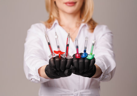 woman cosmetologist holds cosmetology syringes close-up, professional skin care for her health, youth and beauty, modern cosmetology and aesthetic medicineの写真素材