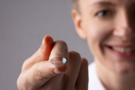 Woman holding contact lens on finger close up, concept alternative to glassesの写真素材