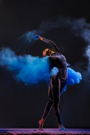 girl dancer in black suit dancing with explosions of colored paints holi on dark background, Concept of art, festival, beauty of dance, inspiration, youthの写真素材