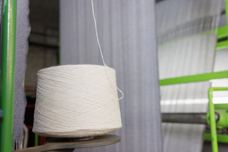bobbin of white woolen threads in production, weaving machine, cotton mill.の写真素材