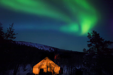 beautiful arctic winter landscape with northern lights, beautiful arctic winter landscape with snowy forest in the background, blue sky and sun setting on the horizon. cold climateの写真素材