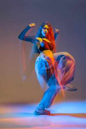 Stylish jazz-funk dancer in motion under vivid studio lighting, with glowing colors and urban dance energy.の写真素材