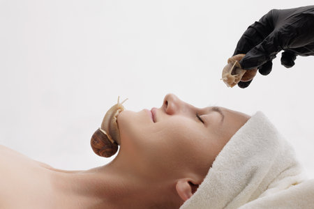 Snail therapy session on a woman face as part of a natural skincare and beauty treatment to hydrate and rejuvenate the skin.の写真素材