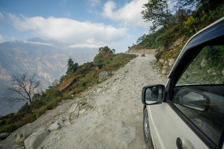 Scenic mountain road journey in Nepal Himalayas with jeep exploring remote landscapes ideal for adventure travelの写真素材