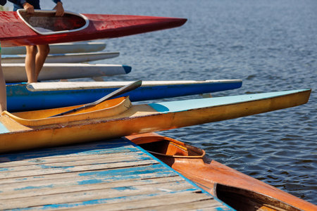 Colorful kayaks lined up at the dock, perfect for training, lessons, or competition in summer water...