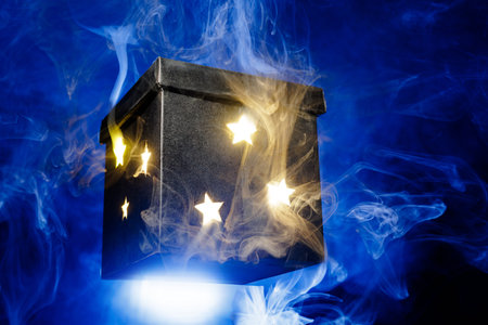 Floating star box glows through swirling blue smoke, ideal for mystery, reveal, product launch, promo or holiday magic.の写真素材