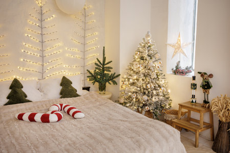 Warm Christmas bedroom with snowy tree, fairy lights and neutral hygge decor, ideal festive winter home interior background for designsの写真素材