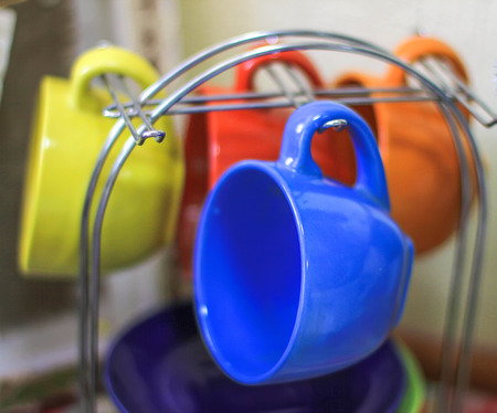 bright colored cups on a support metal dishes at home, in a cafe, drinkingの写真素材