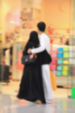 Arab sheikhs men and their wives and families in a mall make a purchase, Dubai, people go to the mall, market, blurred for backgroundの写真素材