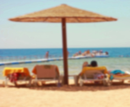 exotic beach with umbrellas, beach vacation on the beach, luxury hotels, blurredの写真素材