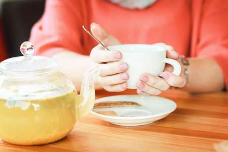 Female hands with a cup of hot tea for cold and temperature. aromatic drink, delicious hot tea....